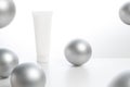 cosmetic lotion beauty cream facial mockup package tube with silver gloss ball decoration on white background in spa healty treatm