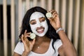 Cosmetic mask, beauty and skin care concept. Pretty African woman with mud clay mask on her face, posing to camera with Royalty Free Stock Photo