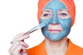 Cosmetic mask on the face. Close-up portrait of a beautiful young woman with a towel on her head having skin care treatments. She Royalty Free Stock Photo