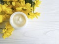 Cosmetic moisturizer cream balm wellness yellow chrysanthemum product flower white wooden Royalty Free Stock Photo