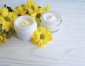 Cosmetic moisturizer cream bright in a jar yellow chrysanthemum product flower white wooden Royalty Free Stock Photo