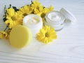 Cosmetic moisturizer cream in a jar yellow chrysanthemum product flower white wooden Royalty Free Stock Photo