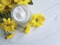 Cosmetic moisturizer cream wellness marguerite yellow chrysanthemum product chamomile white wooden Royalty Free Stock Photo