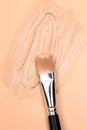 Cosmetic natural pastel concept. The texture of foundation cream with a cosmetic brush on a beige background. Makeup base. Very