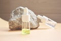 Cosmetic oil in a bottle with a pipette for the face and body on a natural background with a decor in the form of a natural stone