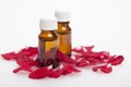 Cosmetic oil in bottles rose in rose petals on a white backgroun