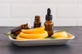 Cosmetic orange oil in a bottle with a dropper and two bottles of essential oil against the background of orange slices Royalty Free Stock Photo