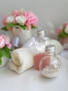 Cosmetic pearl bottles, towel, bouquet of soap flowers on white background. Royalty Free Stock Photo