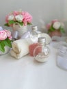 Cosmetic pearl bottles, towel, bouquet of soap flowers on white background. Royalty Free Stock Photo