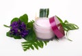 Cosmetic pink cream with herbs and flowers