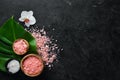 Cosmetic pink sea salt. On a black stone background. Spa treatments. Top view. Royalty Free Stock Photo