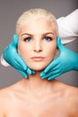 Cosmetic plastic surgeon touching aesthetics face