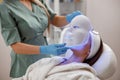 Cosmetic procedure with LED facial mask for female face. Photon therapy