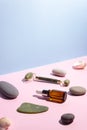 Cosmetic product in a glass bottle with a pipette and gua sha e scraper and roller. Smooth stones nearby. The concept of skin care