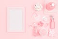 Cosmetic products for bathroom, health and hygiene in modern girlish style with blank wooden frame for text, advertising on pink. Royalty Free Stock Photo