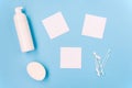 Cosmetic products on a blue background. Facial foam, soap and cotton buds. Three white sheets of paper for text. Body and skin