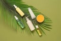 Cosmetic products for face and body. Cream, mask, lotion, oil on artificial palm leaves. Green olive paper background Royalty Free Stock Photo