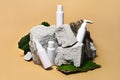 Cosmetic sample white bottle set on stone, moss, wooden podium on beige background. Travel vacation accessories