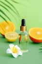 Cosmetic serum Vitamin C in glass bottle with pipette dropper citrus and plumeria flower. Orange essential oil with Royalty Free Stock Photo