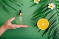 Cosmetic serum Vitamin C in glass bottle with pipette dropper in female hand. Orange essential oil with citrus Vitamin C Royalty Free Stock Photo