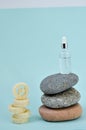 Cosmetic serum in white dropper bottles on natural stone. Blue background natural skincare products concept