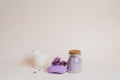 Cosmetic spa set for body care. Sea salt in a glass jar, organic soap, candle and lilac flowers on a light background Royalty Free Stock Photo