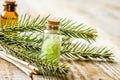 Cosmetic spruce oil and salt in bottles with fur branches on wooden table background Royalty Free Stock Photo