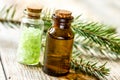 Cosmetic spruce oil and salt in bottles with fur branches on wooden table background Royalty Free Stock Photo