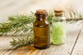 Cosmetic spruce oil and salt in bottles with fur branches on wooden table background Royalty Free Stock Photo