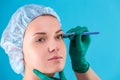 Cosmetic surgeon examining female client in office. Doctor checking woman`s face, the eyelid before plastic surgery Royalty Free Stock Photo