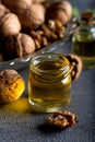 Cosmetic and therapeutic walnut oil on wooden background. Walnut oil in bottle and nuts on a dark background Royalty Free Stock Photo