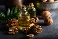 Cosmetic and therapeutic walnut oil on wooden background. Walnut oil in bottle and nuts on a dark background Royalty Free Stock Photo