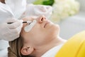 Cosmetician giving eyelash treatment to customer