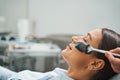 Cosmetician hand applying a charcoal mask on her client face