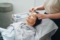 Cosmetician massaging her client forehead with acupressure metal roller massagers