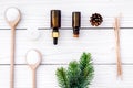 Cosmetics and aromatherapy concept. Pine spa salt, oil, pinecones and spruce branch on white wooden background top view Royalty Free Stock Photo