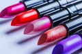 Cosmetics and beauty industry, a set of lipsticks on a background of loose powder and eye shadow, High Angle Still Life of Four