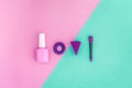 Cosmetics on colorful background. Pink nail polish and violet eyeshadow applicator on pink and mint background top view