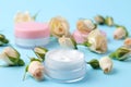 Cosmetics for face and body. Cream in pink bottles with fresh roses on a gentle blue background. creams and lotion. spa Royalty Free Stock Photo