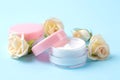 Cosmetics for face and body. Cream in pink bottles with fresh roses on a gentle blue background. creams and lotion. spa Royalty Free Stock Photo