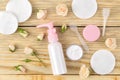 Cosmetics for face and body. Cream in pink bottles with fresh roses on a natural wooden background. creams and lotion. spa. top vi Royalty Free Stock Photo