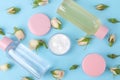 Cosmetics for face and body in pink bottles with fresh roses on a gentle blue background. creams and lotion. spa. top view Royalty Free Stock Photo