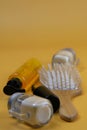 Cosmetics for hair care with jojoba, argan or coconut oil. Oil bottles and combs on orange background