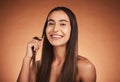 Cosmetics, hair care and young woman pride with natural beauty, healthy and confident with brown studio background Royalty Free Stock Photo