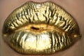 Cosmetics and make-up. Gold lips lipstick and gloss. Sexy and sensual lips. Golden lips closeup. Golden effect on the