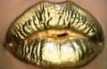 Cosmetics and make-up. Gold lips lipstick and gloss. Sexy and sensual lips. Golden lips closeup. Golden effect on the