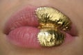 Cosmetics and make-up. Gold lips lipstick and gloss. Sexy and sensual lips. Golden art design.