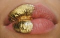 Cosmetics and make-up. Gold lips lipstick and gloss. Sexy and sensual lips. Golden art design.