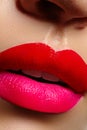 Cosmetics, makeup. Bright lipstick on lips. Closeup of beautiful female mouth with red and pink lip makeup. Part of face