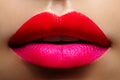 Cosmetics, makeup. Bright lipstick on lips. Closeup of beautiful female mouth with red and pink lip makeup. Part of face